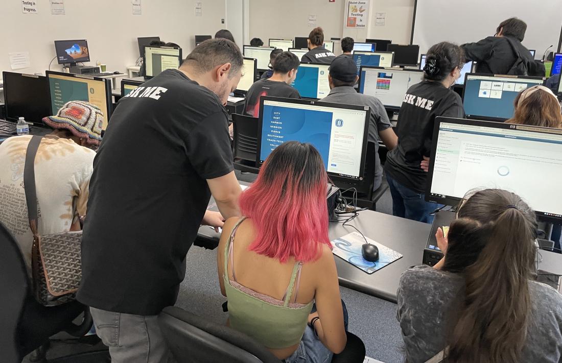 Students in computer lab receiving assistance from representatives