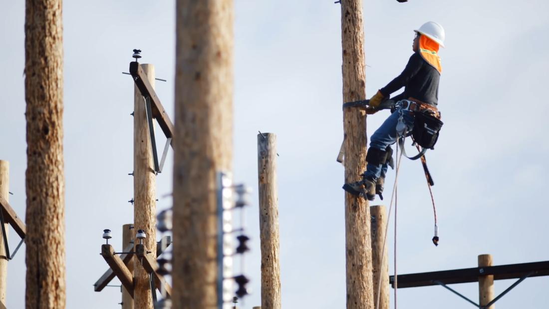 Powerline worker climbing pole