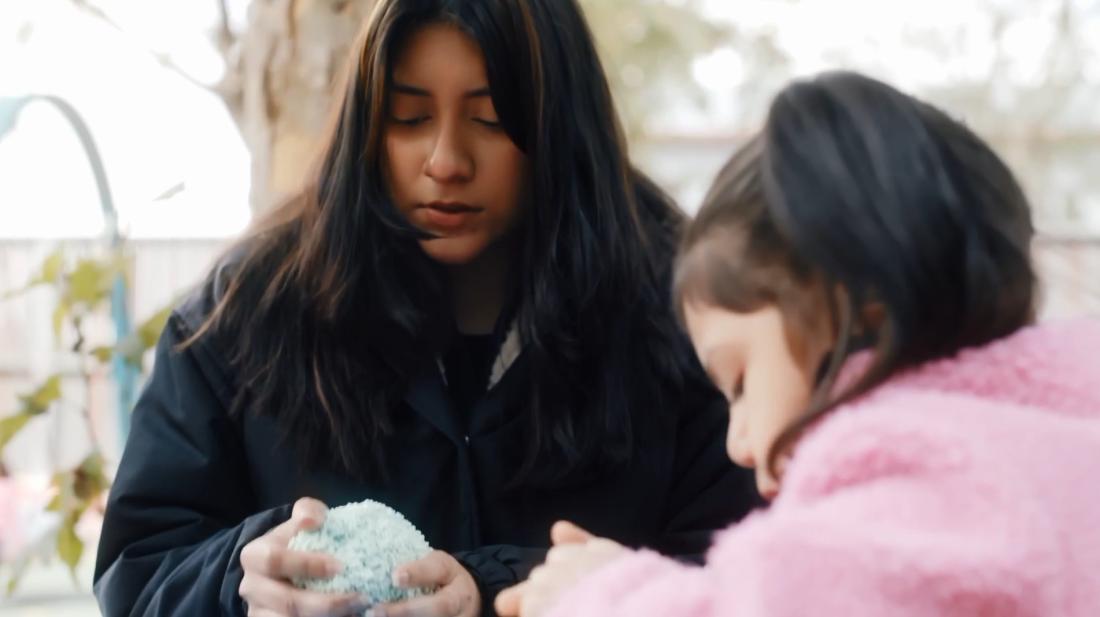 Student working on clay with child