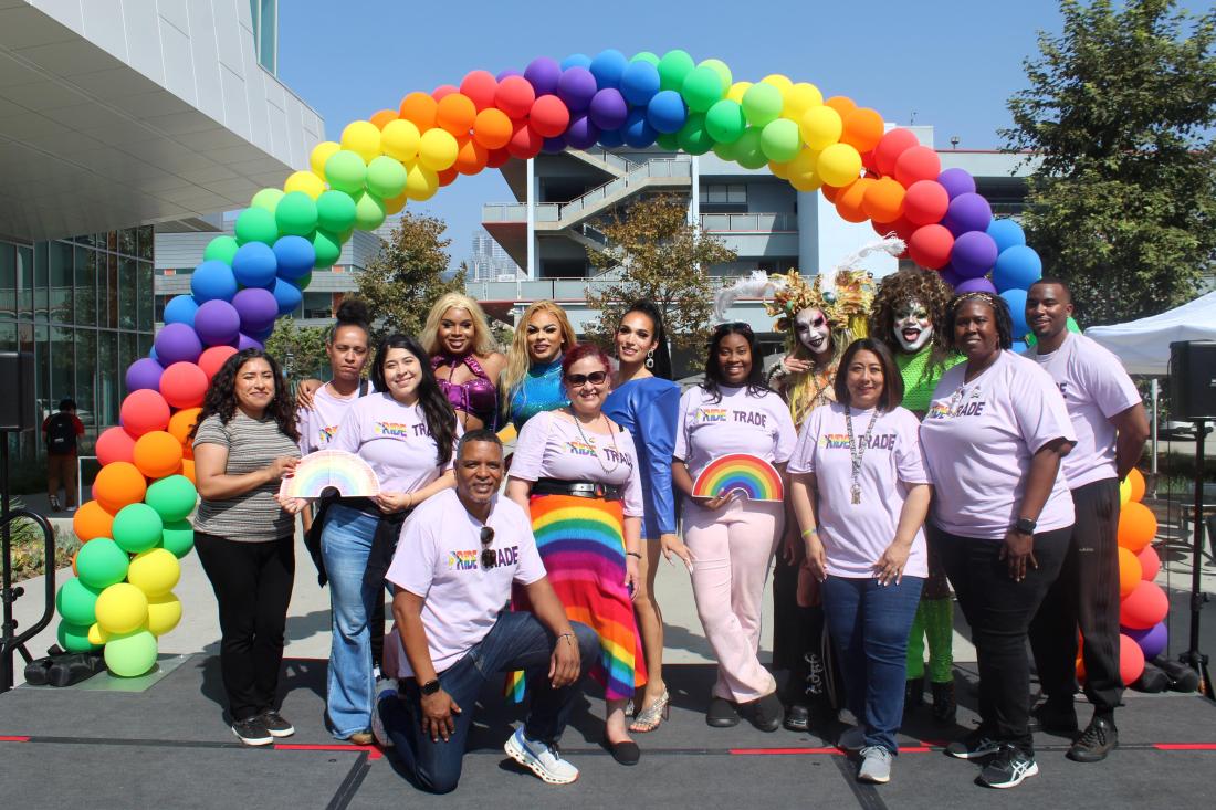 LATTC Pride Club, administrators and drag artists post on stage against rainbow balloons