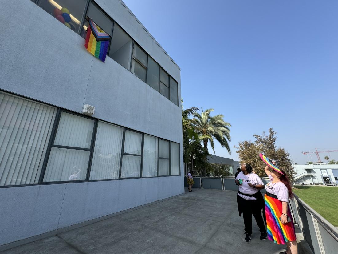 LATTC Pride Flag is raised as viewers look on